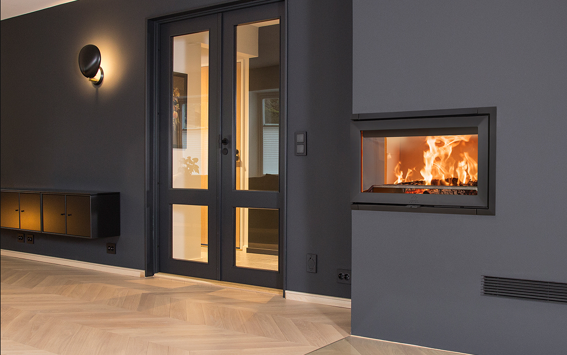 Jøtul I 620 FL på sort vegg. Foto.