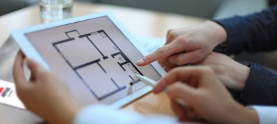 Händer som pekar på iPad med Jøtul-katalog