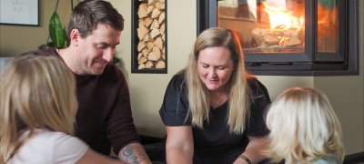 Familjen sitter och spelar spel i vardagsrummet framför Jøtul I 620 FR spisinsats