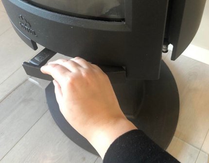 Hand som öppnar eldstadsdörren till vedspisen Jøtul F 373 Gå försiktigt fram 