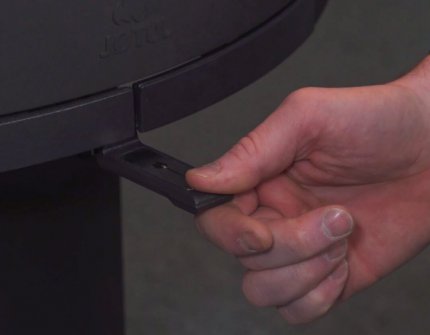 Hand som reglerar lufttillförseln i eldstaden