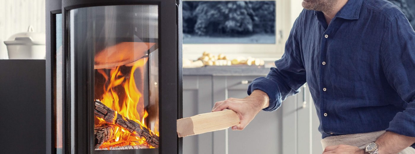 Man som skjuter i en Jøtul -eldstad