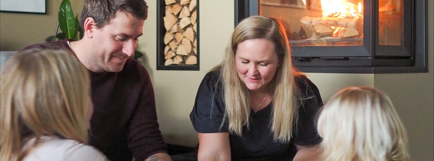 Familjen sitter och spelar spel i vardagsrummet framför Jøtul I 620 FR spisinsats