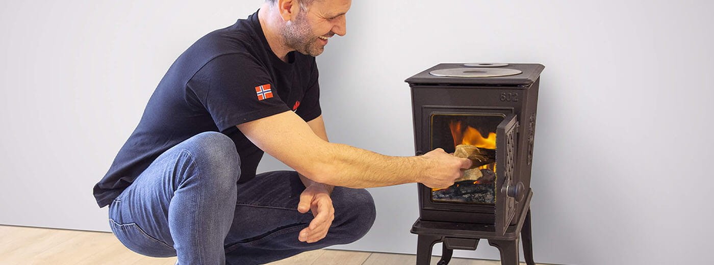 Man lägger ved i vedspisen Jøtul F 602