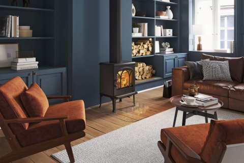 Jøtul F 200 svart klassisk vedspis framför mörkblå vägg