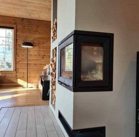 Vit omramning med en svart insats kallad Jøtul I 520 FR i en norsk stuga.
